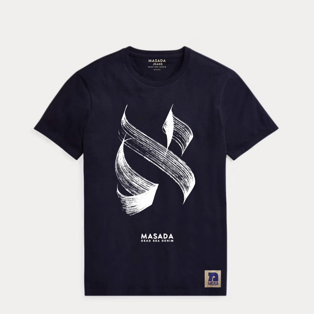 The Aleph white T-shirt is crafted from premium cotton and showcases a bold black brushstroke Aleph, MASADA DEAD SEA DENIM printed below, and a small rectangular hem patch, all inspired by Israeli culture.