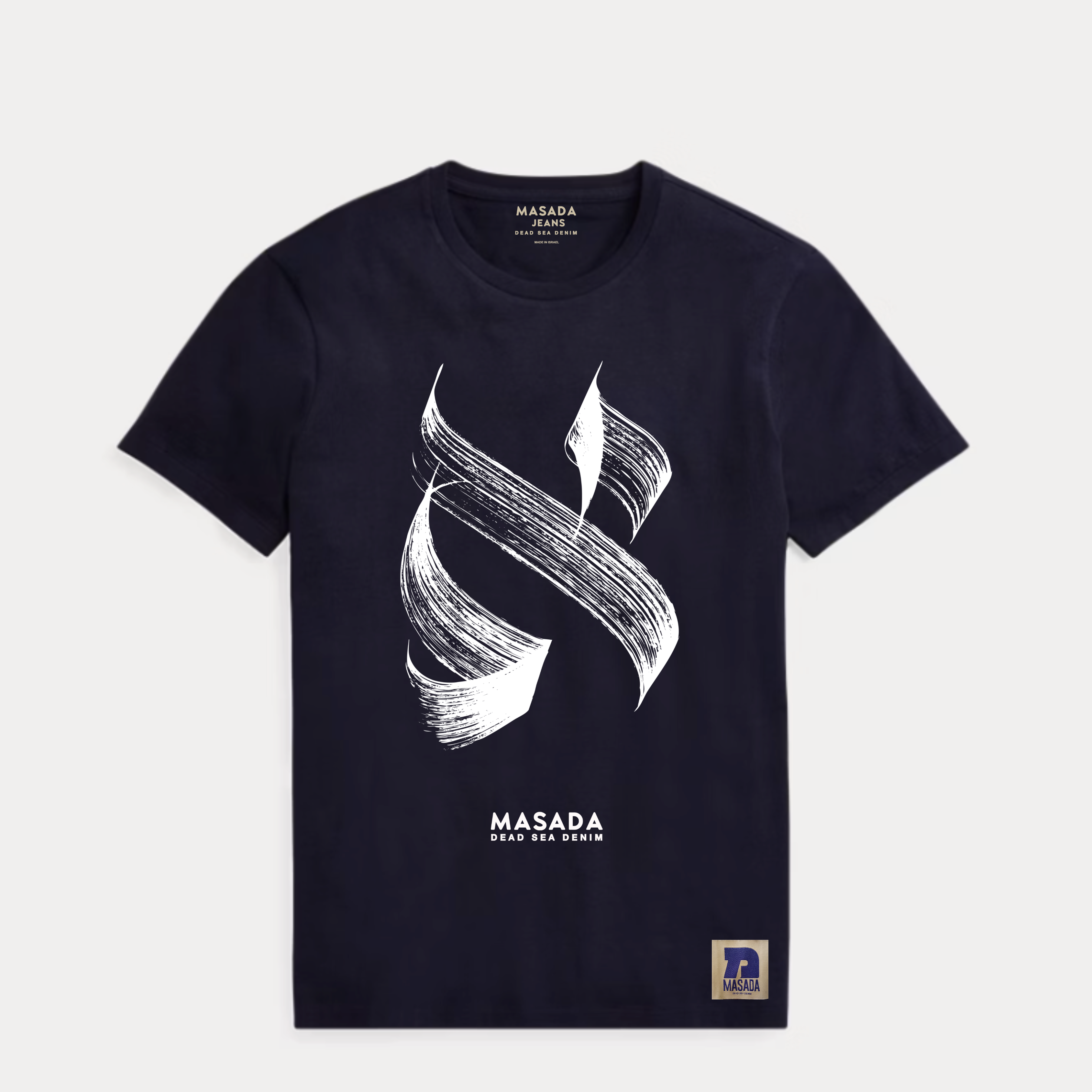 The Aleph white T-shirt is crafted from premium cotton and showcases a bold black brushstroke Aleph, MASADA DEAD SEA DENIM printed below, and a small rectangular hem patch, all inspired by Israeli culture.