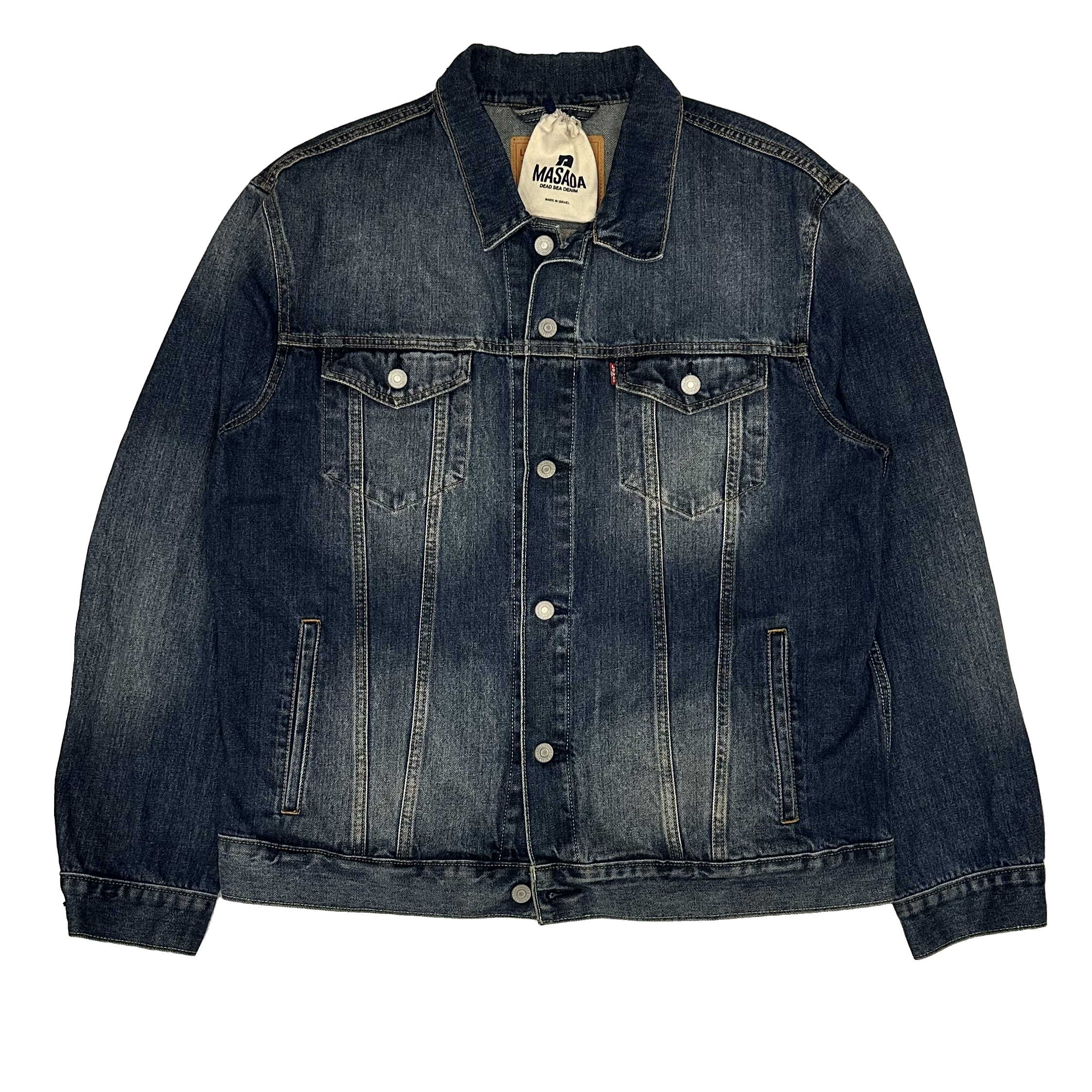 The NEGUEV TRUCKER JACKET is a classic blue denim style with silver buttons, two flap chest pockets, and subtle fading. Inspired by the iconic Trucker Jacket, it’s laid flat on a white background for a timeless appeal.